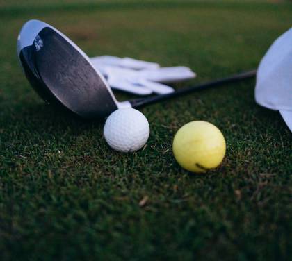 Golfschläger und Bälle liegen auf dem Green