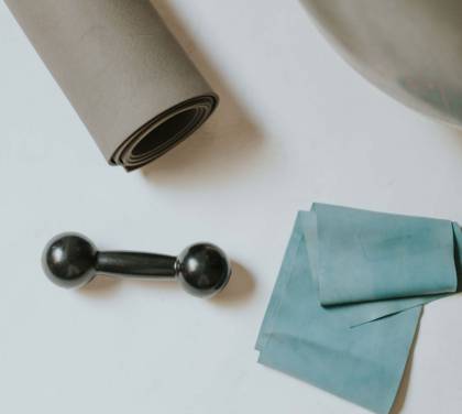 Yogamatte und Hantel liegen auf dem Boden