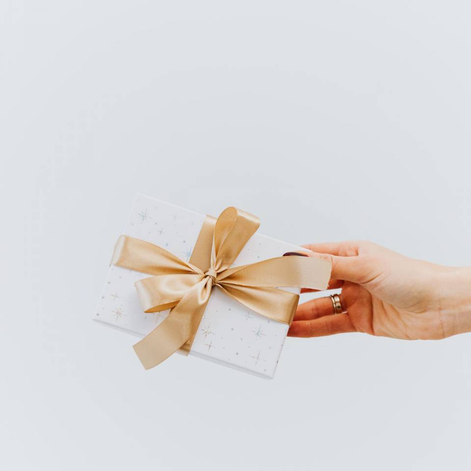 Frau hält ein kleines Geschenk in der Hand