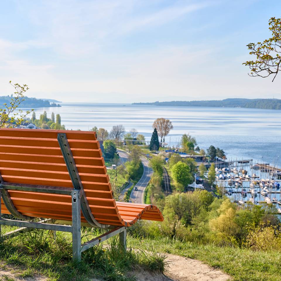 Holzbank auf einer Anhöhe mit Blick über den Bodensee